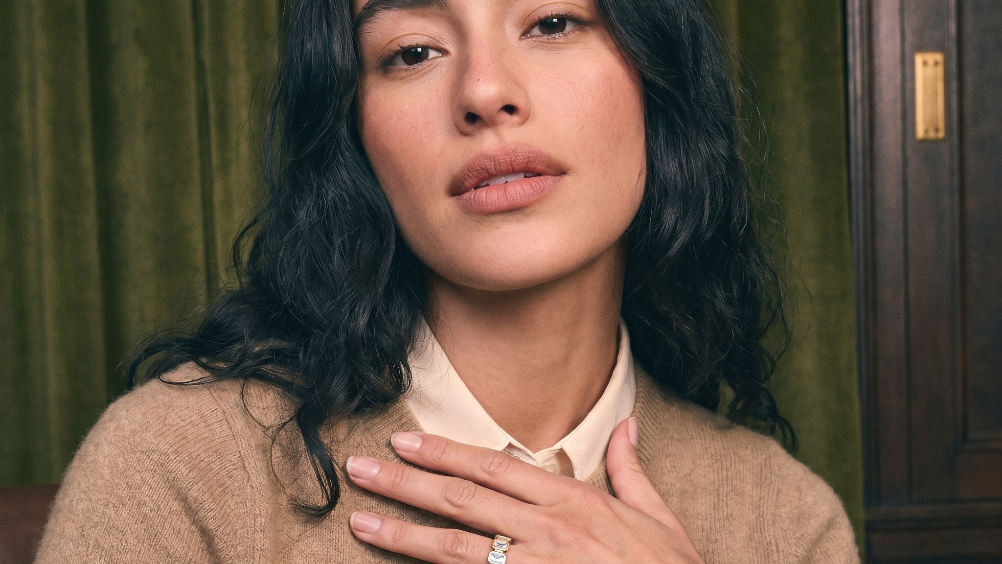 Lab grown diamond color seen in a bezel-set emerald cut gold eternity band worn on the hand in natural light