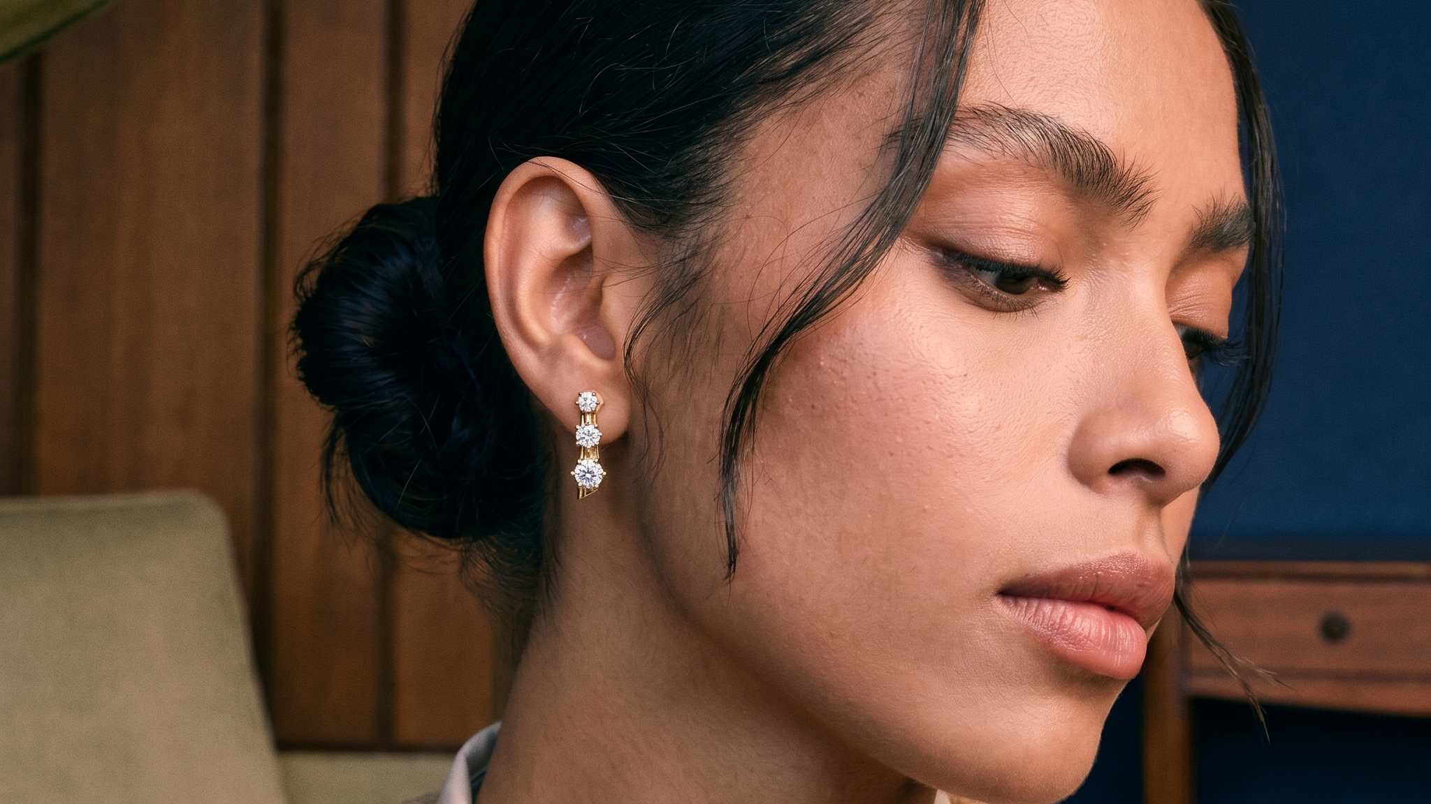 Model wearing a round brilliant lab grown diamond stud earring in solid gold, soft natural light