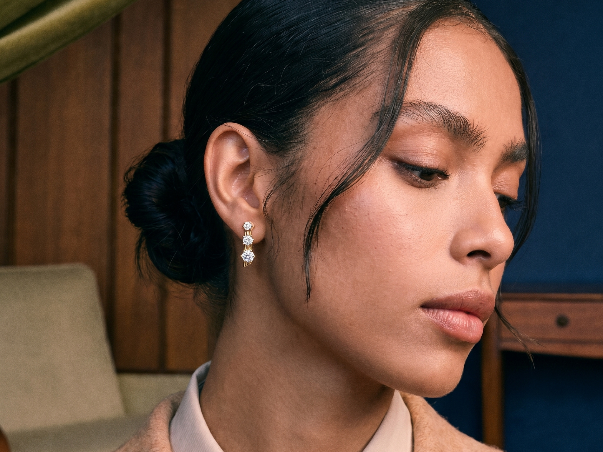 Model wearing a round brilliant lab grown diamond stud earring in solid gold, soft natural light