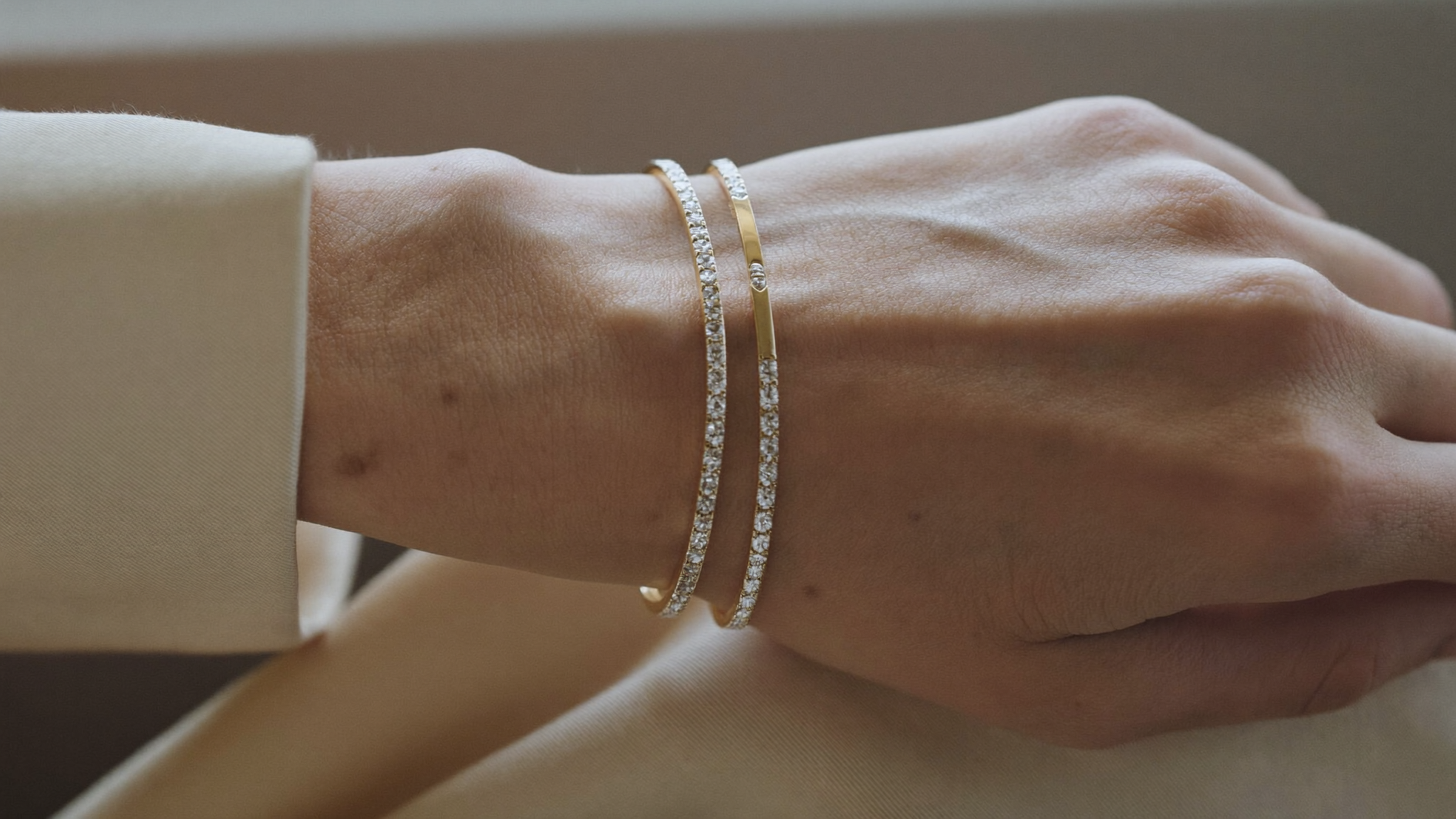 Woman's wrist layered with two slim solid gold lab grown diamond tennis bracelets, illustrating the 2026 tennis jewelry trend