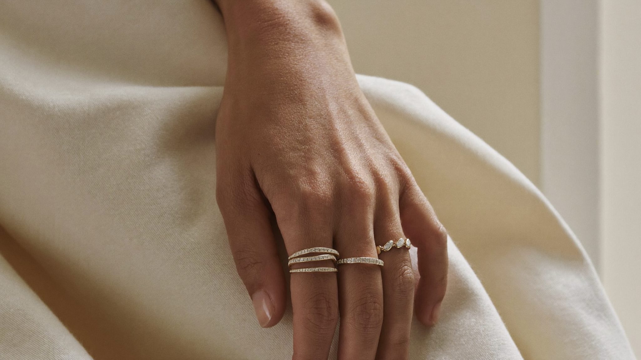 How to stack rings: four slim solid gold lab grown diamond bands stacked on one finger in soft natural light